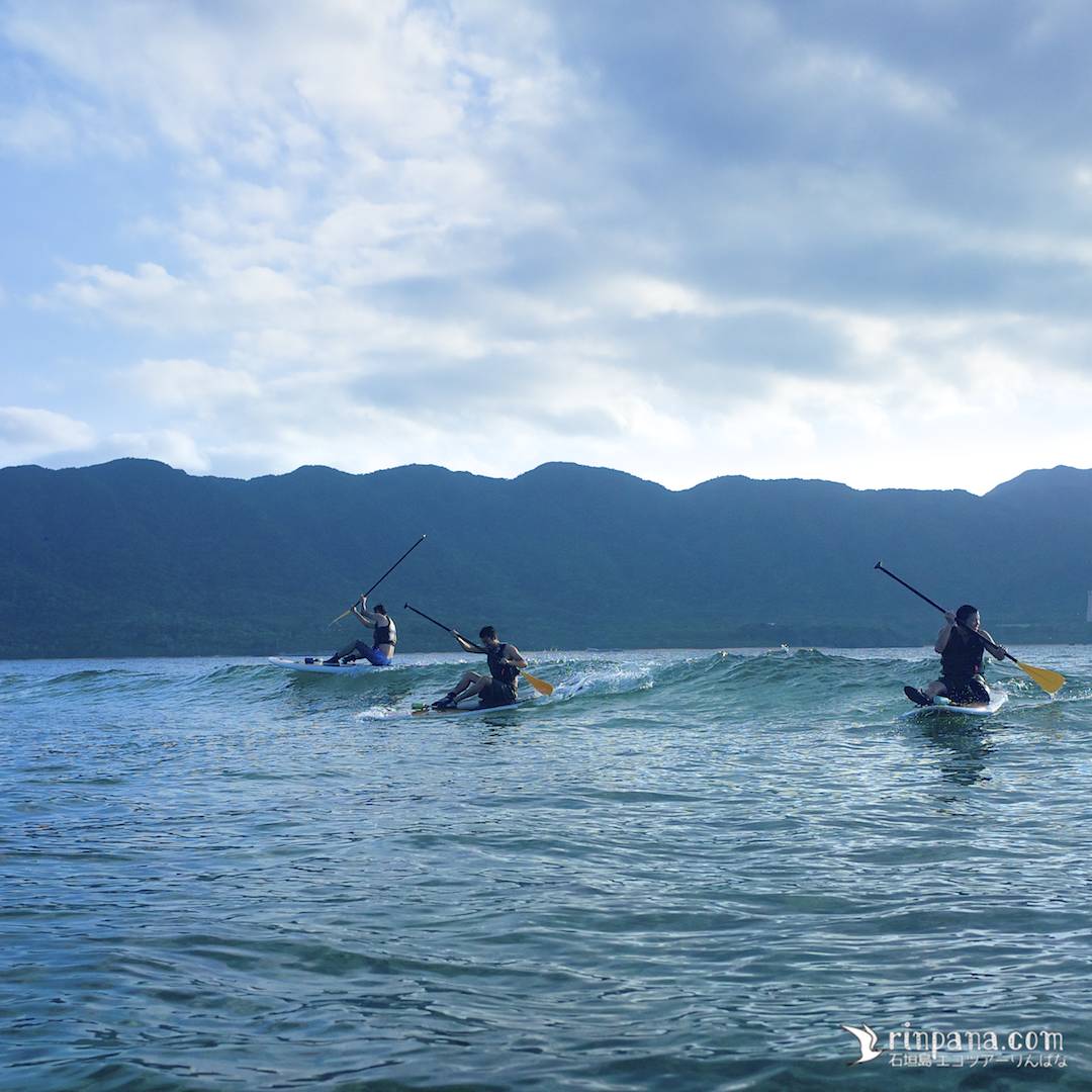 SUPで同じ波に乗る3人
