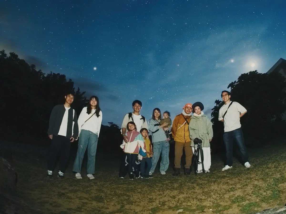 満天の星空の下、記念撮影をするツアー参加者の集合写真