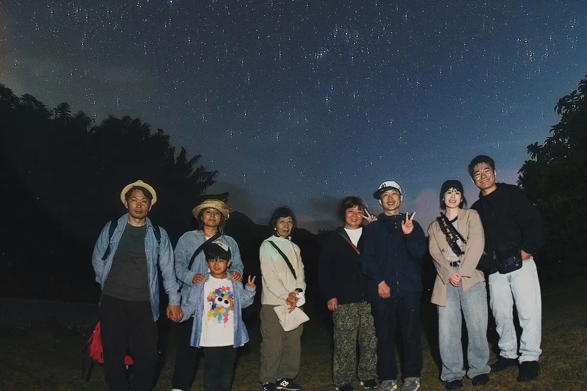 石垣島の澄んだ夜空に広がる無数の星々と、笑顔で映るツアー参加者たちのポートレート